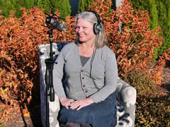 Stacey Hirvela podcaster on Every Plant Deserves a Podcast in the garden with her recording equipment.